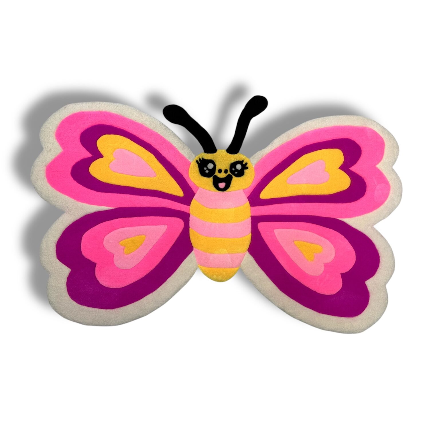 Handmade tufted pink butterfly rug for kids, full front view on floor.