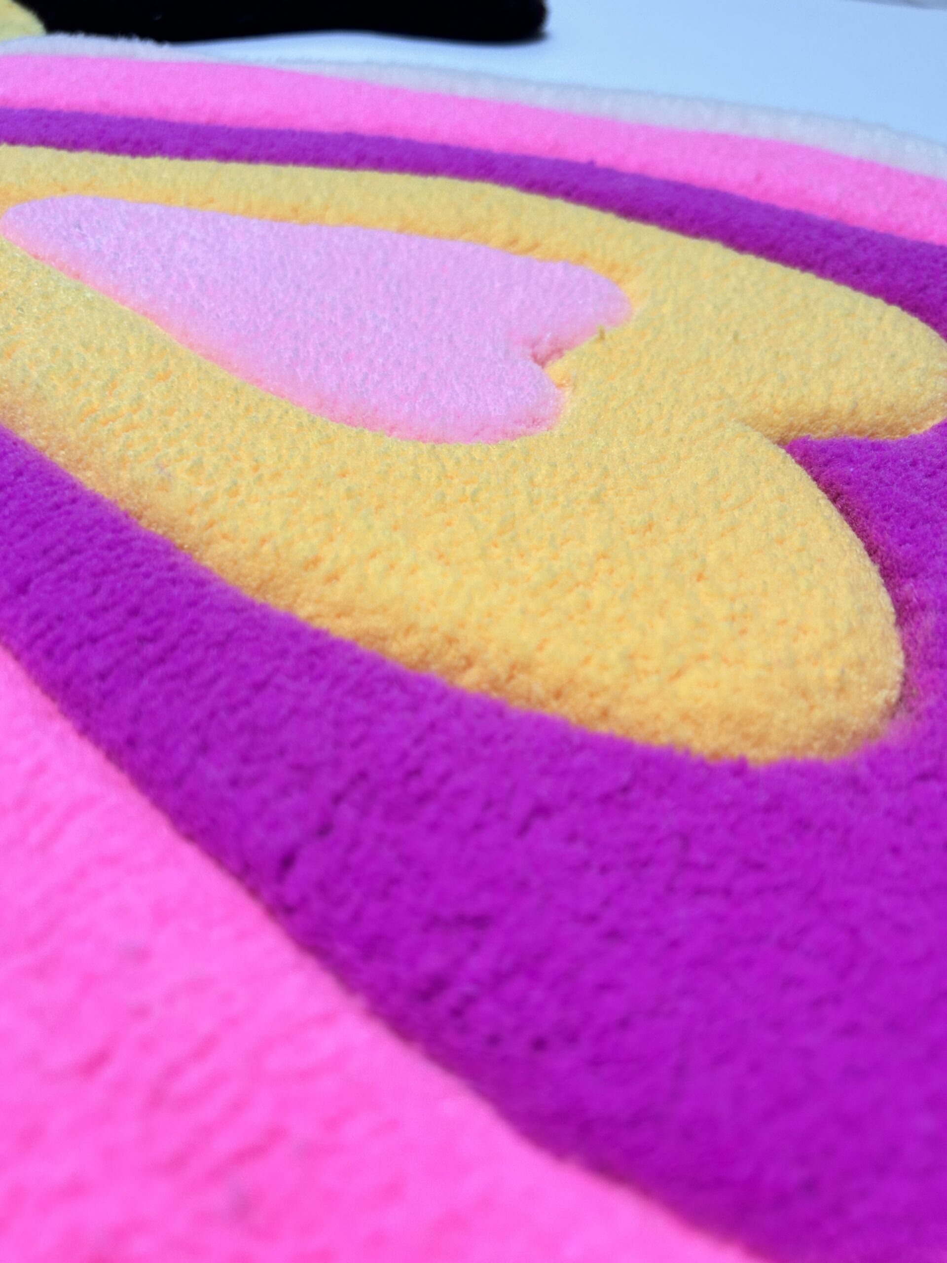 Detailed stitching and vibrant colors on pink butterfly handmade rug.