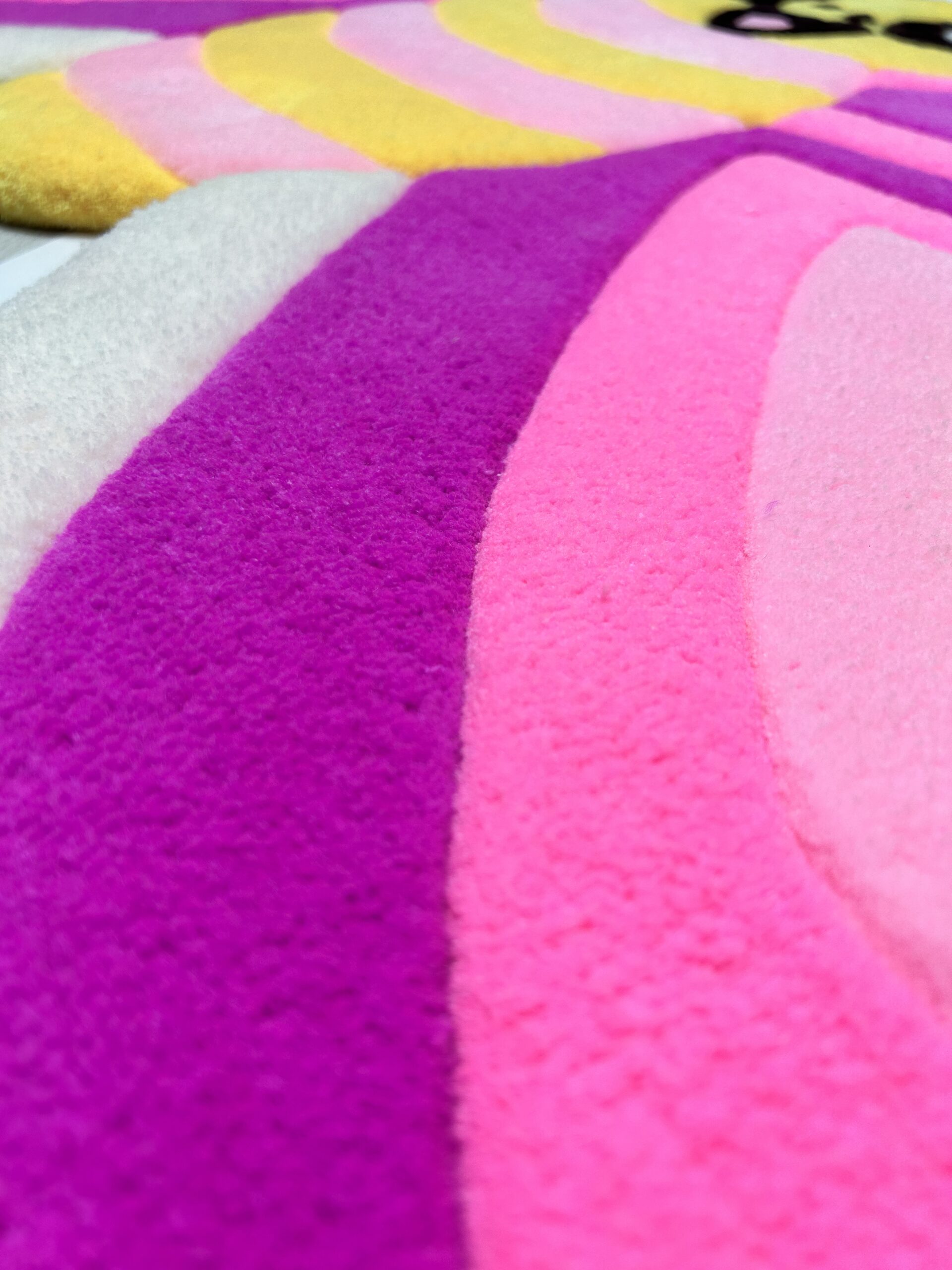 Tufted surface of kids pink butterfly rug showing plush yarn texture.